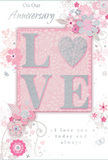 The anniversary card in the image offers a gentle, romantic composition, blending soft pastel pinks with silvery greys to create the feeling of a treasured, intimate moment shared somewhere quiet off Clapham High Street. At its heart, the word LOVE is spelled out in raised, velvety glitter, with each letter slightly lifted from the surface to invite touch. The letter O is replaced by a shimmering silver heart, textured so it seems to glow softly, mirroring the gleam of a delicate pendant or a polished keepsake. Surrounding this central motif, a cluster of illustrated blooms in blush, mauve, and ivory unfurls with the softness of watercolour, their edges gently blurred as though seen through a light morning mist. Fine, flowing lines define slender stems and leaves, curving gracefully across the card like vines across a garden wall near Clapham Common. Tiny flourishes-petals, swirling curls, and discreet butterflies-add a sense of movement and whimsy, suggesting the flutter of excitement that comes with another year together. The background is a muted, rosy pink, providing a warm, reassuring base for the cooler silvery accents. Above and below the focal design, the phrases On Our Anniversary and I love you today and always are written in understated, elegant script, the lettering slim and poised, echoing a note carefully written by hand. Overall, the card feels like a paper bouquet crafted by a thoughtful local florist, the visual equivalent of a soft-spoken promise, perfect for marking an anniversary evening at home or a quiet celebration after a stroll through Clapham's tree-lined streets.